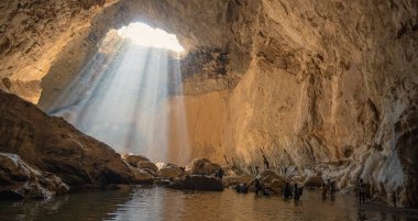 Meksika 'daki Kakahuamilpa ya da Chontalcoatlan Nehri' nin mağaralarının içinde bir yeraltı nehrinde yürüyen yürüyüşçüler.