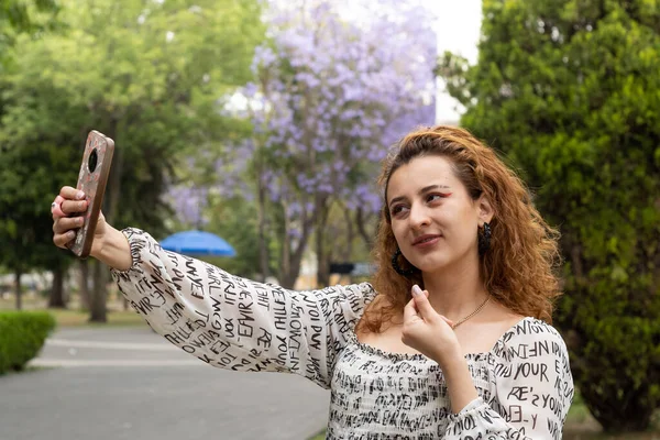 Jonge Vrouw Met Behulp Van Haar Mobiele Telefoon Een Park — Stockfoto