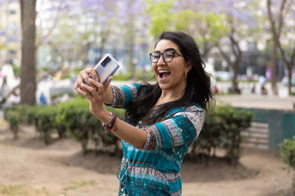 Jonge Vrouw Met Behulp Van Haar Mobiele Telefoon Een Park — Stockfoto
