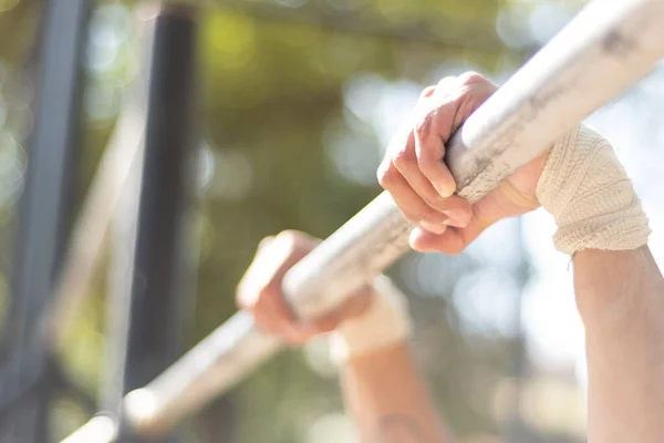 Genç adam parkta jimnastik yapıyor.