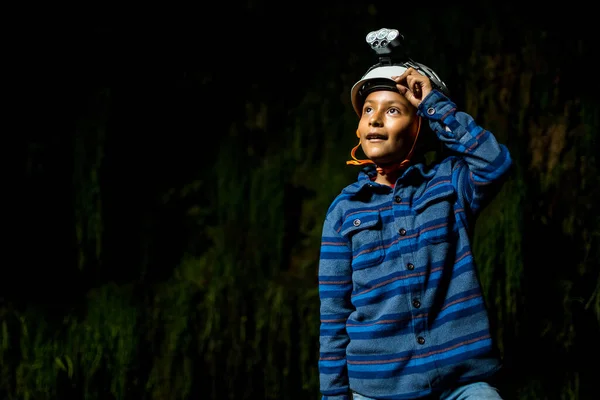男孩儿头戴安全帽在山洞里打洞 — 图库照片