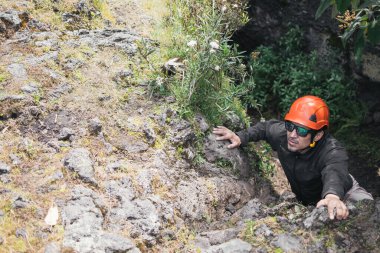 Kasklı yürüyüşçü manzaraya bakıyor.