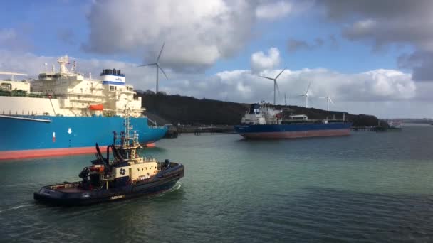 2022年2月25日 ボートは 英国ウェールズのペンブローク港で2022年2月25日に丘の上に風力タービンを備えた大きな船を通過します 高品質4K映像 — ストック動画