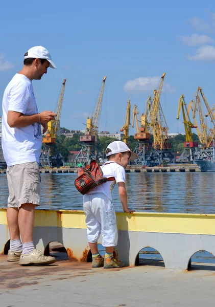 Uomo e bambino sul molo vicino al porto marittimo — Foto Stock