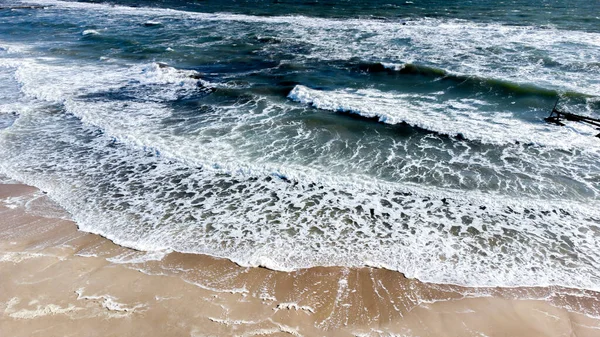 Voo de visão aérea de drones sobre ondas do mar que rolam para a costa arenosa. — Fotografia de Stock