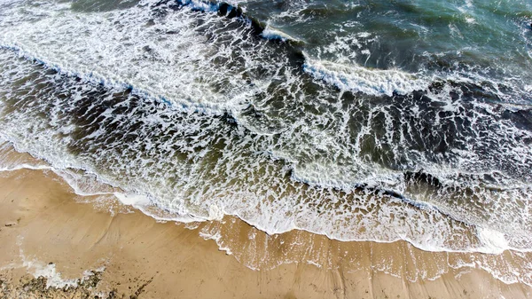 Voo de visão aérea de drones sobre ondas do mar que rolam para a costa arenosa. — Fotografia de Stock