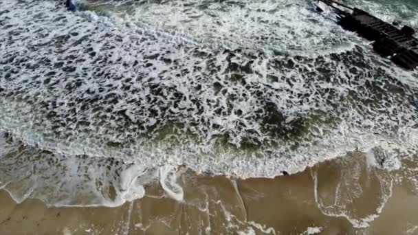 Aerial drone view flight over sea waves that roll onto sandy shore. — Stock Video