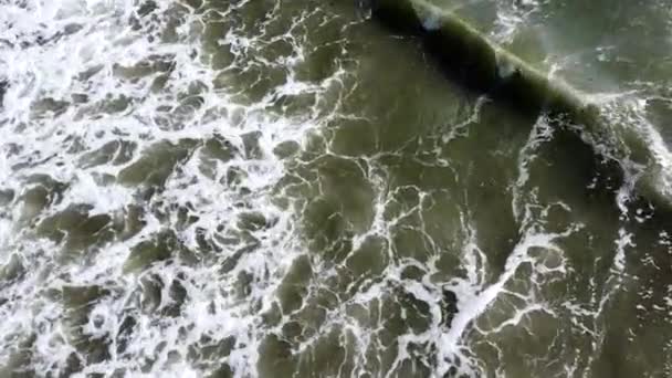 Dron powietrzny widok lotu nad falami morskimi, które toczą się na piaszczystym brzegu. — Wideo stockowe