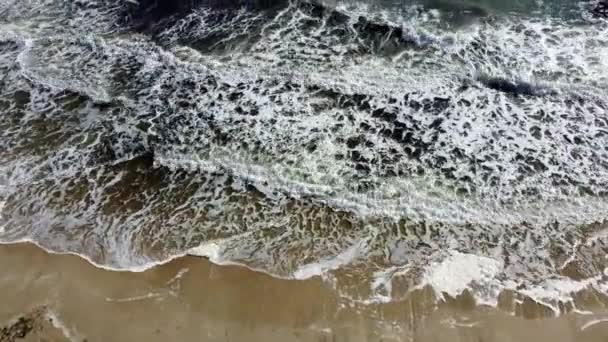 Avión teledirigido vuelo sobre las olas del mar que rodar sobre la orilla arenosa. — Vídeos de Stock
