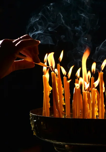 Mano humana enciende una vela en la iglesia — Foto de Stock