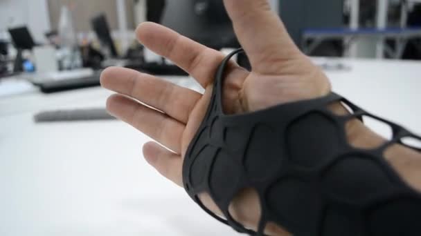 Zwarte orthopedische plastic prothese gedrukt op poeder 3D printer bij de hand. — Stockvideo