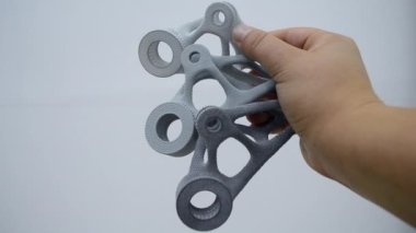Elinde tuttuğu kişi toz 3D yazıcıya yakın plan basılmış..
