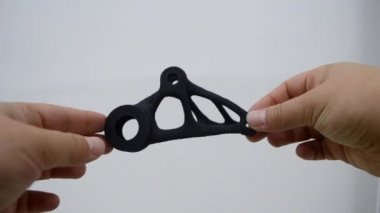 Elinde tuttuğu kişi toz 3D yazıcıya yakın plan basılmış..