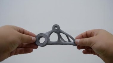 Elinde tuttuğu kişi toz 3D yazıcıya yakın plan basılmış..