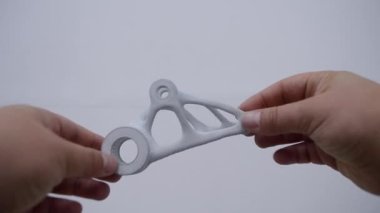Elinde tuttuğu kişi toz 3D yazıcıya yakın plan basılmış..