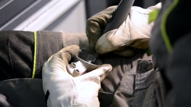 A munkás fémdarabokat őröl közelről. Kézi munkanadrágban lévő személy — Stock videók