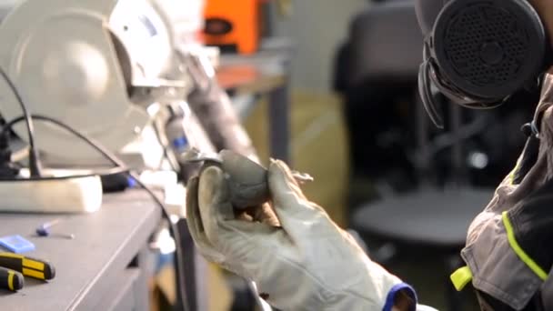 Trabajador moliendo detalle de metal de cerca. Persona en guantes de trabajo manualmente — Vídeos de Stock