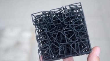 Kişi elinde 3D yazıcıya basılmış bir nesne tutar.