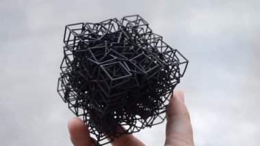 Kişi elinde 3D yazıcıya basılmış bir nesne tutar.