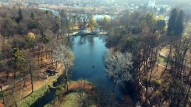 Güneşli bir sonbahar gününde göl üzerinde parktaki Arial drone manzaralı uçuş