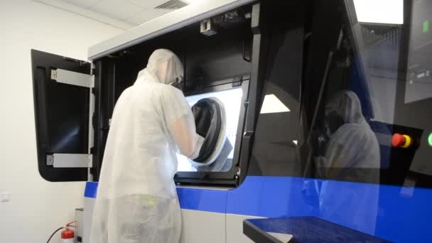 Personne en salopette blanche fonctionne avec une machine avec de grandes manchons en caoutchouc — Video