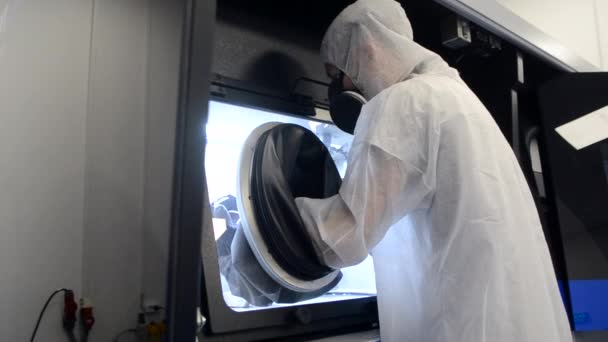 Persoon in witte overall werkt met machine met grote rubberen mouwen — Stockvideo