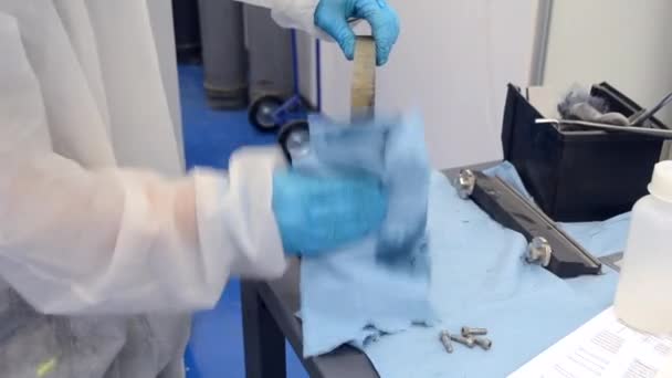 Travailleur en costume de protection blanc et gants de protection bleus Nettoyage partie métallique — Video