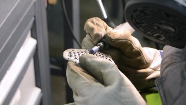 O homem no trabalho uniforme mói o detalhe metálico pela mão close-up. Moagem detalhe de metal — Vídeo de Stock