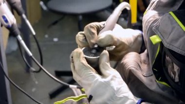 İş üniformalı bir adam, metal parçalarını yakın plan çekimle öğütür. Öğütücü metal detayı