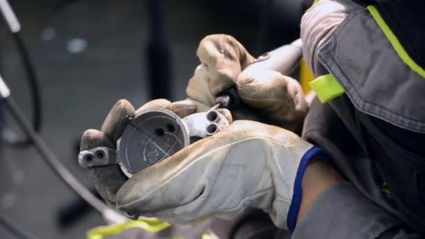 Muž v pracovní uniformě brousí kovové detaily ručně zblízka. Broušení kovových detailů — Stock video