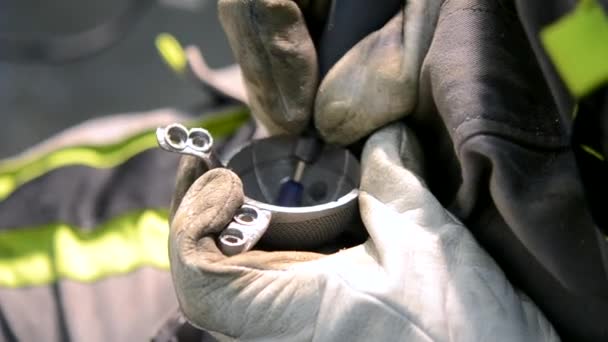 O homem no trabalho uniforme mói o detalhe metálico pela mão close-up. Moagem detalhe de metal — Vídeo de Stock