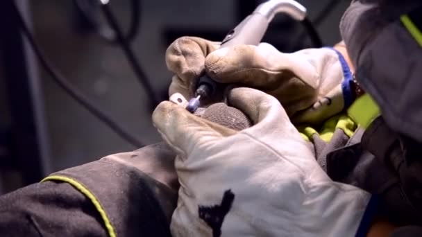 O homem no trabalho uniforme mói o detalhe metálico pela mão close-up. Moagem detalhe de metal — Vídeo de Stock