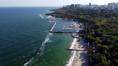 İnsanlar güneşli bir günde sahilde yürüyüp dinleniyorlar. Hava Aracı Görünümü Uçuşu