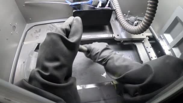 Manlig arbetare i gummihandskar rengör utskriftsplattform inuti 3D-skrivare för metall — Stockvideo
