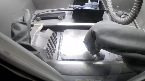 Männlicher Arbeiter im Gummihandschuh reinigt Druckplattform im Inneren des 3D-Druckers für Metall — Stockvideo