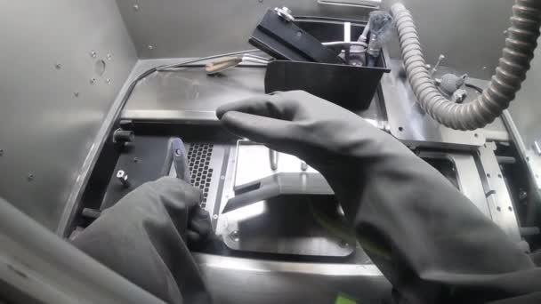 Trabajador masculino en guante de goma limpia la plataforma de impresión dentro de la impresora 3D para metal — Vídeo de stock