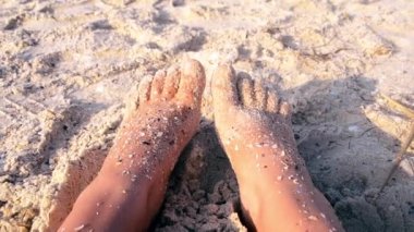 İki çıplak ayak beyaz kadın kumlu deniz kıyısında kum kabuğuna bulanmıştı.