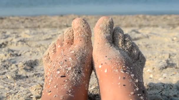 Two bare feet of caucasian woman soiled in sand shell rock on sandy sea shore — Vídeo de Stock