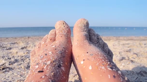 İki çıplak ayak beyaz kadın kumlu deniz kıyısında kum kabuğuna bulanmıştı. — Stok video
