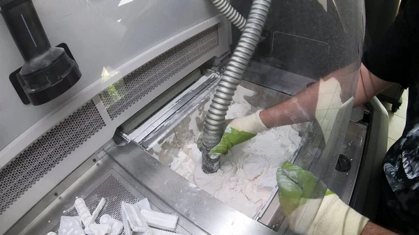 Mann reinigt auf industriellem 3D-Drucker gedruckte Details aus weißem Kunststoffpulver — Stockfoto