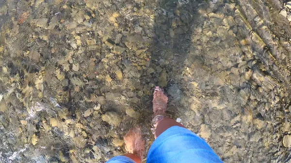 소녀는 맑은 여름날얕은 강의 바위 위를 맨발로 걸어 다닌다 — 스톡 사진