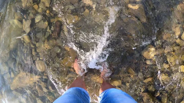 Fille se tient pieds nus sur des pierres rivière peu profonde — Photo