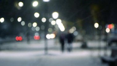 Şehir manzaralı ışıklar, yağan kar, gece caddesi, arabaların farları.