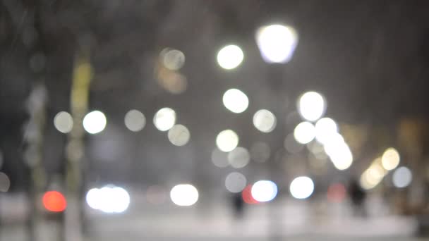 Luzes da vista da cidade, neve caindo, rua noturna, pontos bokeh de faróis de carros — Vídeo de Stock