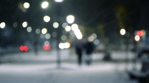 City view lichten, vallende sneeuw, nacht straat, bokeh vlekken van koplampen van auto 's — Stockvideo