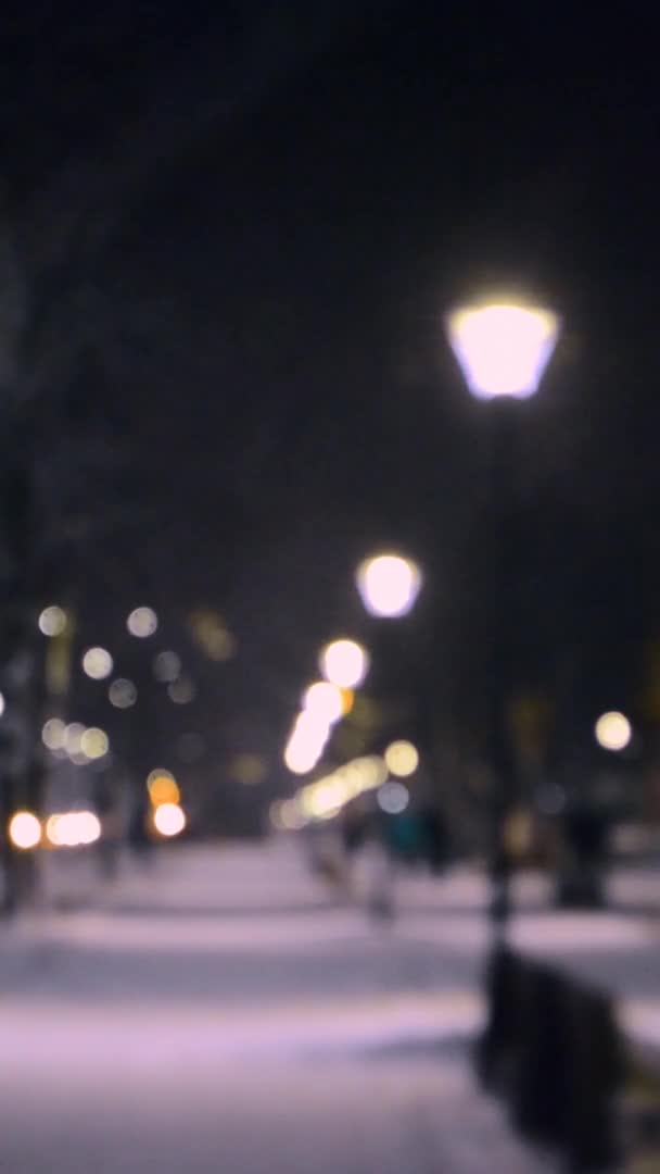 Luzes da vista da cidade, neve caindo, rua noturna, pontos bokeh de faróis de carros — Vídeo de Stock