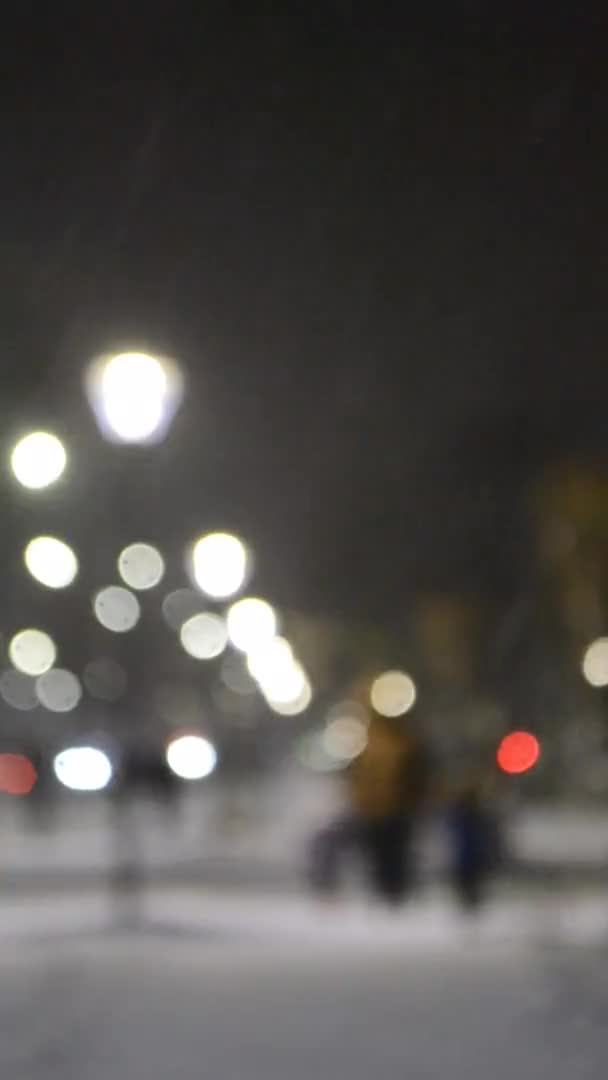 Şehir manzaralı ışıklar, yağan kar, gece caddesi, arabaların farları. — Stok video
