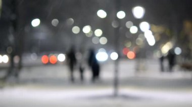 Şehir manzaralı ışıklar, yağan kar, gece caddesi, arabaların farları.