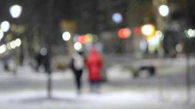 Şehir manzaralı ışıklar, yağan kar, gece caddesi, arabaların farları.