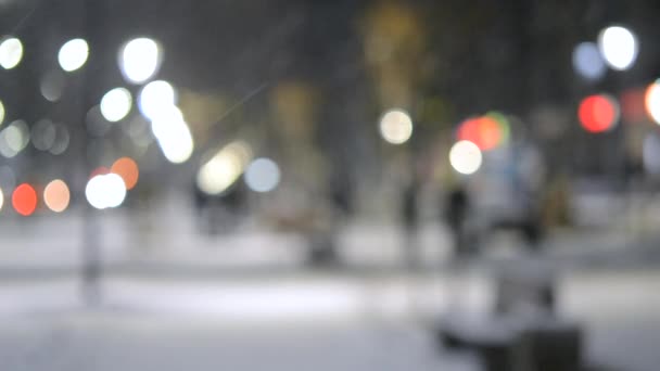 Luzes da vista da cidade, neve caindo, rua noturna, pontos bokeh de faróis de carros — Vídeo de Stock